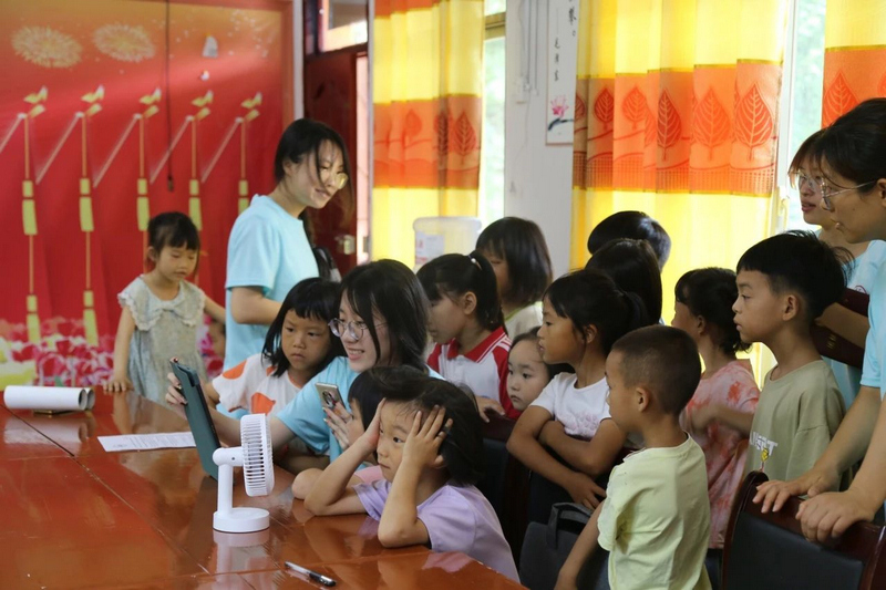 实践团队正带领农村少年儿童观看贵州红色纪念馆云展厅相关学习视频。77779193永利官网供图